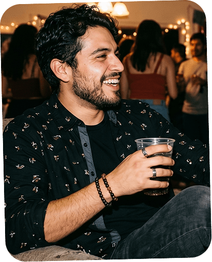 A man at a party holding a drink.